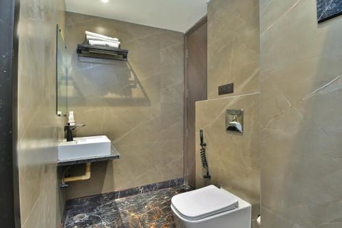 a bathroom with a toilet and a sink at Hotel Uptown Delhi - By La Exito Hotels in New Delhi