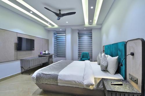 a bedroom with a large bed with a ceiling fan at Hotel Uptown Delhi - By La Exito Hotels in New Delhi