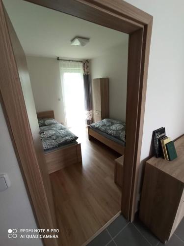 a mirror reflection of a bedroom with two beds at Penzion U Tomanů in Jaroměřice na Rokytné