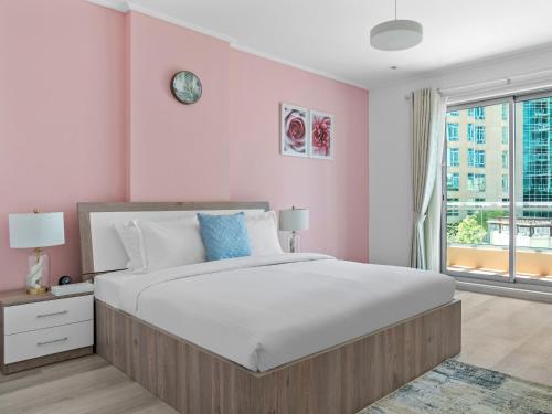 a bedroom with a large bed and a pink wall at Lush Interior Brand New 1BDR-Heart of Downtown in Dubai