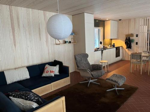 ein Wohnzimmer mit einem blauen Sofa und einer Küche in der Unterkunft A unique lakeside cottage in Rovaniemi