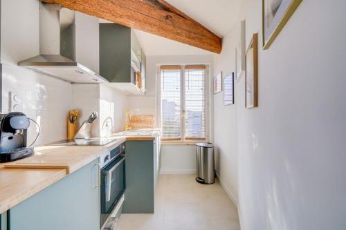 - une cuisine avec des murs blancs et un comptoir en bois dans l'établissement Nice renovated apartment Bordeaux, à Bordeaux