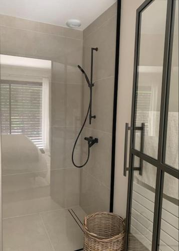 une salle de bain avec une douche avec une porte vitrée dans l'établissement Logement avec hammam - 130 m2 et jardin - Terre de Cocon, à Perrignier