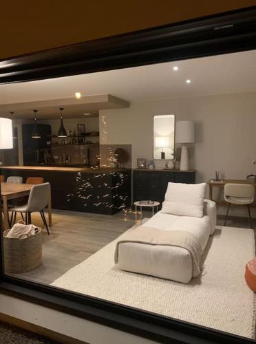 - une chambre avec un lit blanc et un salon dans l'établissement Logement avec hammam - 130 m2 et jardin - Terre de Cocon, à Perrignier