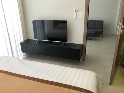 a bedroom with a tv and a bed and a mirror at Novaworld Phan Thiết- 7Days mart in Phan Thiet