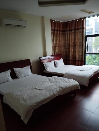 2 camas en una habitación con ventana en Thảnh Đạt Motel, en Hai Phong