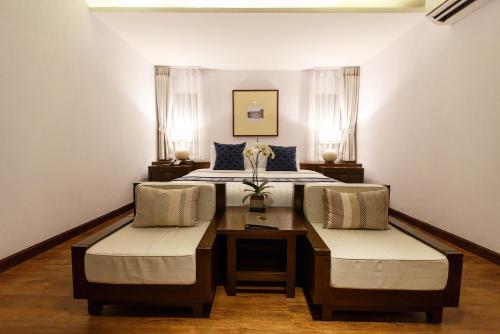清邁的住宿－清邁蘭特瑞酒店，一间卧室配有一张带两把椅子和一张桌子的床。