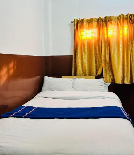 a bedroom with a bed with a yellow curtain at Hotel Sumeru in Kathmandu