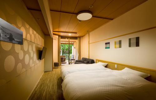 a hotel room with two beds and a chair at Sennomori in Ise