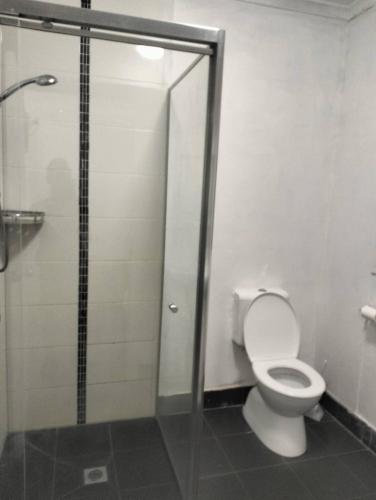 a bathroom with a toilet and a glass shower stall at cliffinn kangaroo point in Brisbane