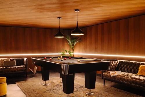 a billiard room with a pool table and a couch at Eden Hotel Amsterdam in Amsterdam