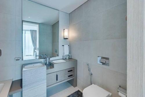 a bathroom with a toilet and a sink and a mirror at Contemporary Designed 1BDR - Address Beach JBR in Dubai