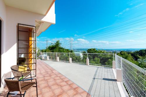a balcony with a view of the ocean at Tropical Soul Okinawa - 135平米1453sqft - Max10 in Teruya