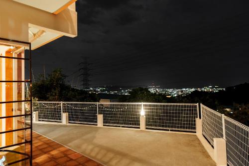 a balcony with a view of a city at night at Tropical Soul Okinawa - 135平米1453sqft - Max10 in Teruya