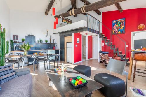 ein Wohnzimmer mit roten Wänden, einem Tisch und Stühlen in der Unterkunft Le Loft du Panier Design Central Vue imprenable in Marseille