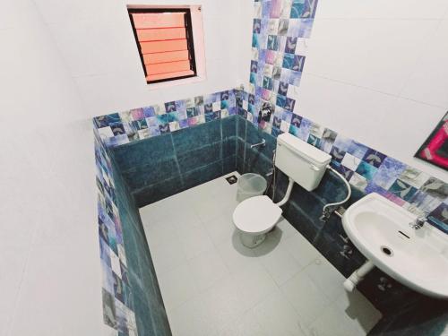 a bathroom with a toilet and a sink at Hotel Adam's Baga Beach Resort Goa - 2 minutes walk from Baga Beach in Baga