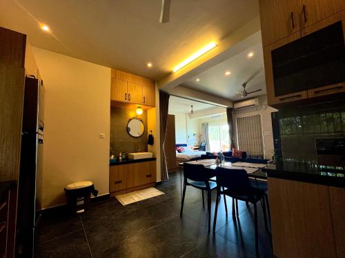 a kitchen and living room with a table and chairs at Green Horizon, Luxury & Nature at Kothamangalam in Kotamangalam