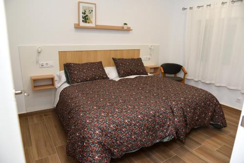 a bedroom with a bed with a brown comforter at LA VILLA DE ORGAZ II in Toledo
