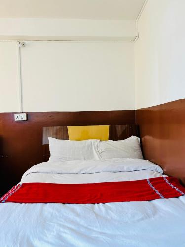 a white bed with a red blanket on it at Hotel Sumeru in Kathmandu