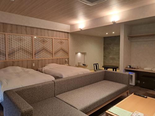 a bedroom with a bed and a couch and a table at Sennomori in Ise