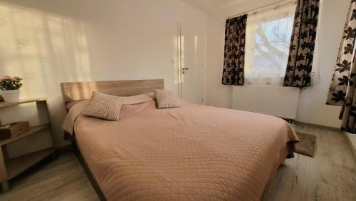 a bedroom with a bed in a room with a window at Fortuna Park Apartman in Sfântu-Gheorghe