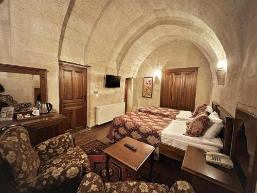 a hotel room with a bed and a couch at Stone House Cave Hotel in Goreme
