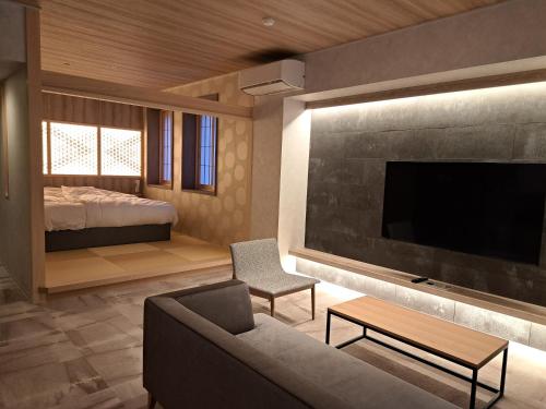 a living room with a couch and a tv and a bed at Sennomori in Ise