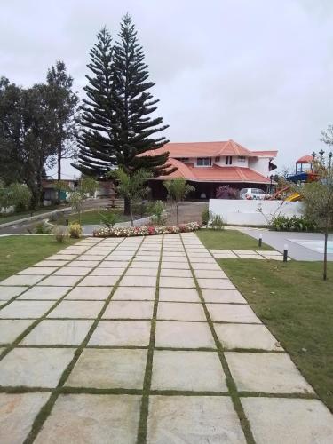 a walkway in front of a house with a tree at HILLOCK BUNGALOW KUTTIKKANAM in Idukki