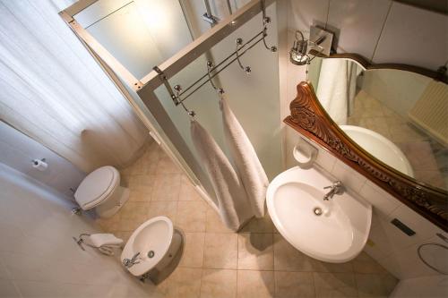 een badkamer met een wastafel, een toilet en een spiegel bij bb26 Buoso apartment city center in Cremona
