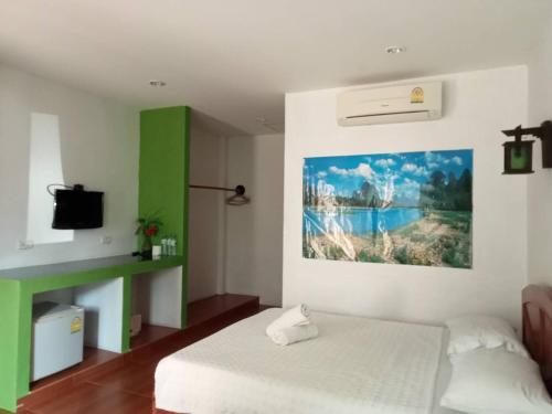 1 dormitorio con 1 cama y una pintura en la pared en Bank Guesthouse, en Haad Rin