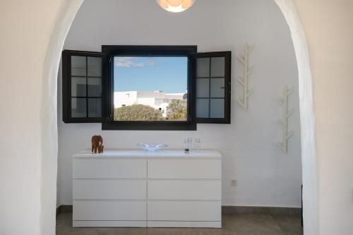 Baño con ventana sobre una cómoda blanca en Casa SAS La Hoya, en Yaiza