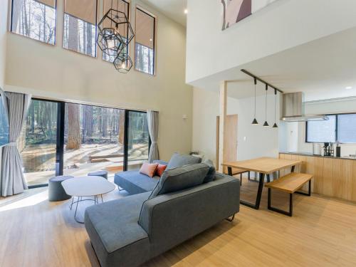 a living room with a couch and a table at Rakuten STAY VILLA Fujikawaguchiko Forest in Fujikawaguchiko