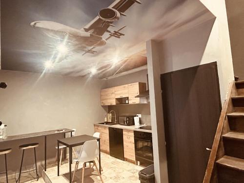 une chambre avec une table et un plan au plafond dans l'établissement LA MARIEFACTURE - Comme à la Tour de Contrôle, à Boulay - Moselle