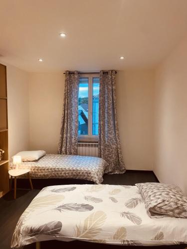 um quarto com 2 camas e uma janela em LA MARIEFACTURE - Comme un Nid Douillet 
