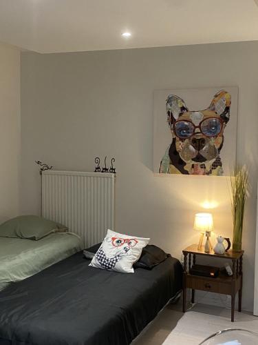 une chambre avec un lit et une peinture d'un chien dans l'établissement LA MARIEFACTURE - Comme Chien et Chat, à Saint-Avold