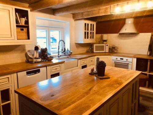 a kitchen with a wooden counter top in a kitchen at LA MARIEFACTURE - Comm chez Mémé in Laning