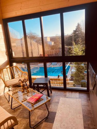 a living room with a view of a swimming pool at LA MARIEFACTURE - Comm chez Mémé in Laning