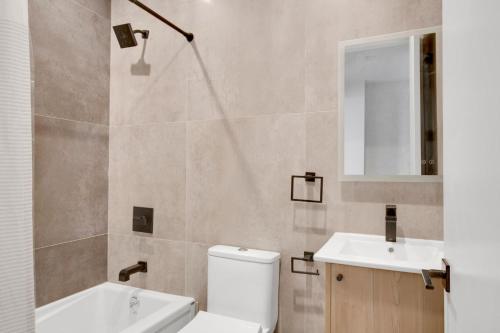 een badkamer met een toilet, een wastafel en een spiegel bij Cobble Hill 1BR w in-unit WD nr Trader Joes NYC-728 in Brooklyn