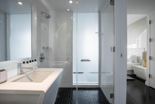 a white bathroom with a sink and a shower at Tribeca studio w elevator nr world trade center NYC-1357 in New York