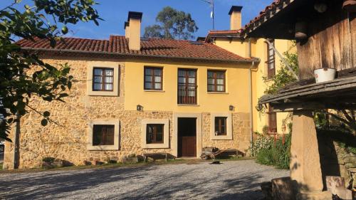 une maison en pierre jaune avec une allée devant elle dans l'établissement Casa Rural Trebol4Hojas, à San Pedro