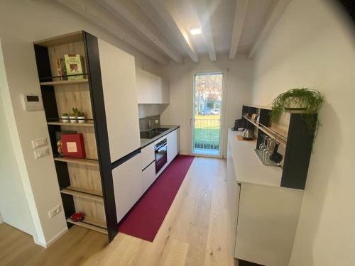 a kitchen with white counters and a large window at Exclusive house in Marostica in Marostica