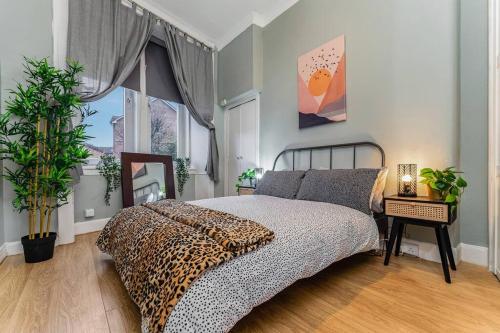 um quarto com uma cama com estampa de leopardo e uma janela em Traditional 1-Bed Flat in Southside (Hampden/Shawlands) em Glasgow