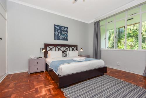 um quarto com uma cama e uma grande janela em Murrayfield 217 em Joanesburgo