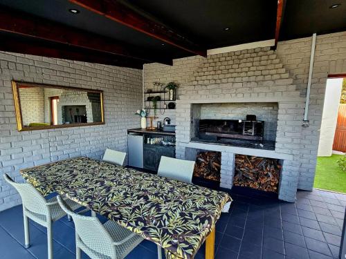a patio with a table and chairs and a fireplace at Mosselbay Dream Home in Mossel Bay