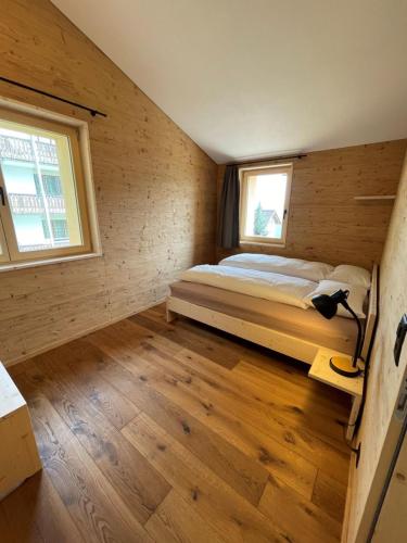 a bedroom with a bed in a room with a window at Ferienwohnungen JHS in Seewis im Prättigau