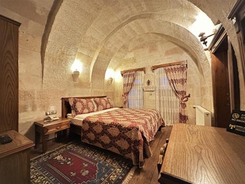 a bedroom with a bed in a stone room at Stone House Cave Hotel in Goreme