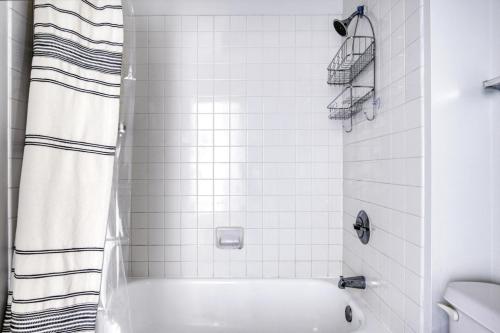 a white bathroom with a tub and a shower at Streeterville Studio w Gym Pool nr Navy Pier CHI-450 in Chicago