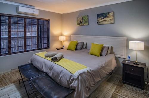 a bedroom with a large bed with green pillows at The South Post @ Kruger in Marloth Park