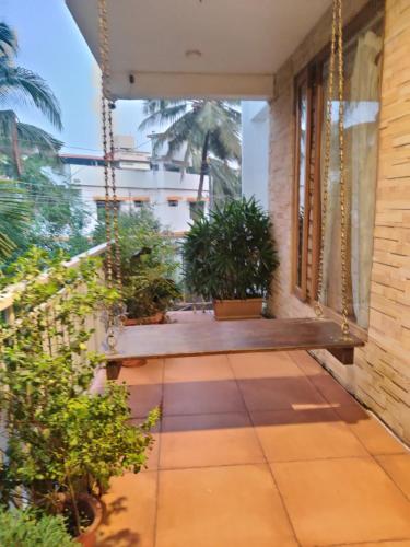 a porch with potted plants and a swing at Laasya Vilaasa in Mangalore
