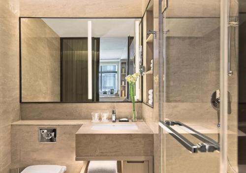 a bathroom with a sink and a mirror at Marriott Executive Apartments Hangzhou Yuhang in Hangzhou